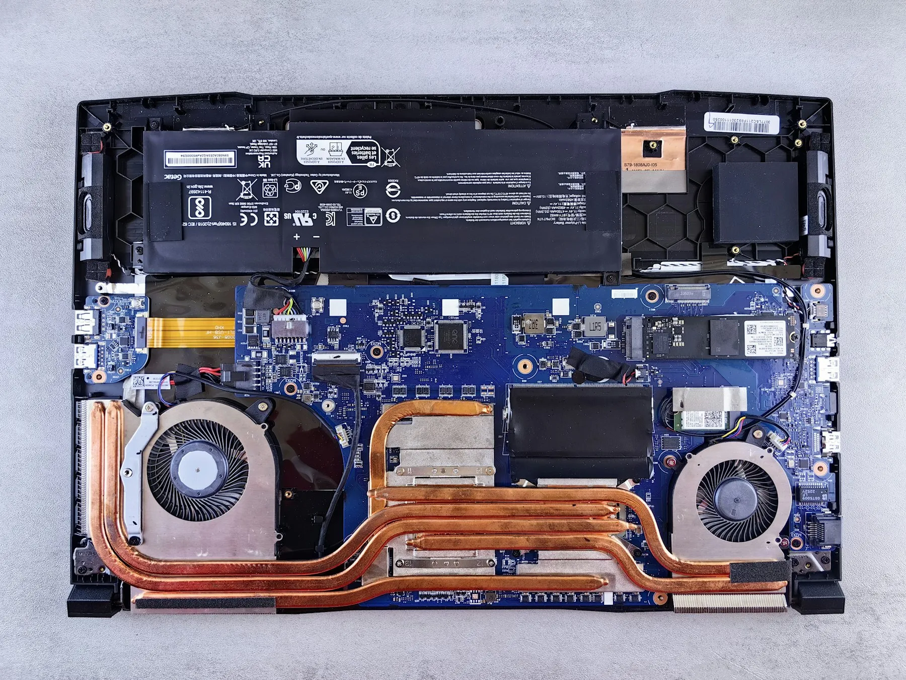 Notebook aberto mostrando placa-mãe, ventoinhas e dissipadores